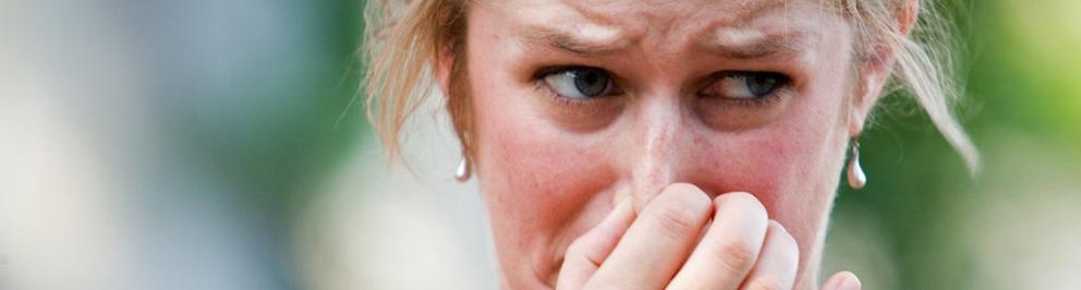 Vrouw knijpt neus dicht