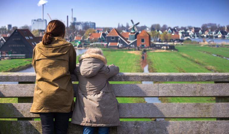 vrouw en kind kijken uit over de weilanden bij de zaanse schans