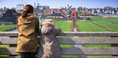 vrouw en kind kijken uit over de weilanden bij de zaanse schans